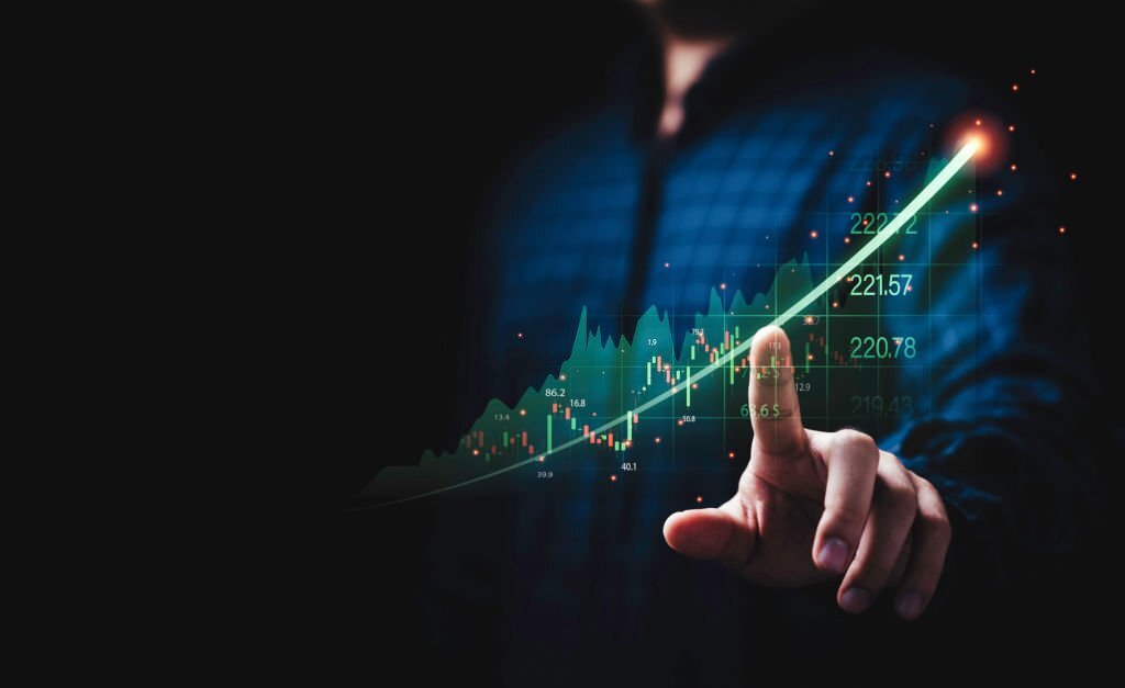 Hand writing statistics increasing arrow with stock market graph for business investment and growth grain profit economy concept.